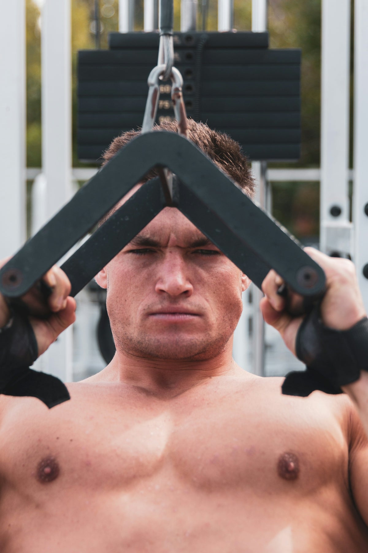 topless man holding black metal bar