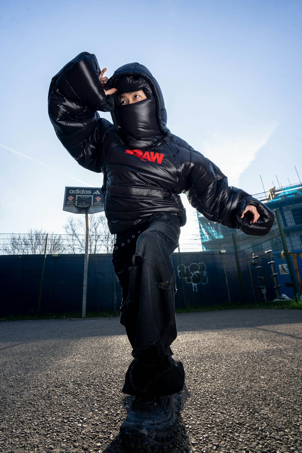 a man in a black jacket is riding a skateboard
