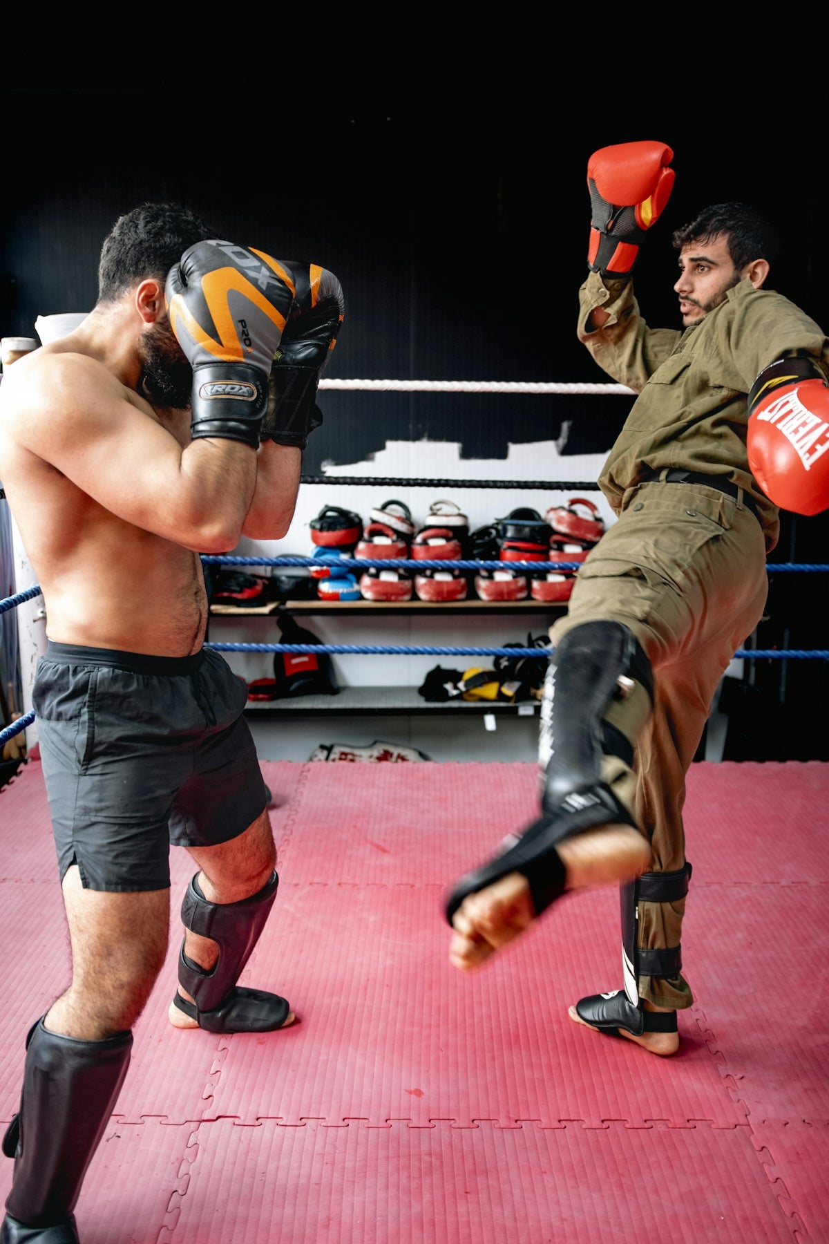 a couple of men standing next to each other in a boxing ring