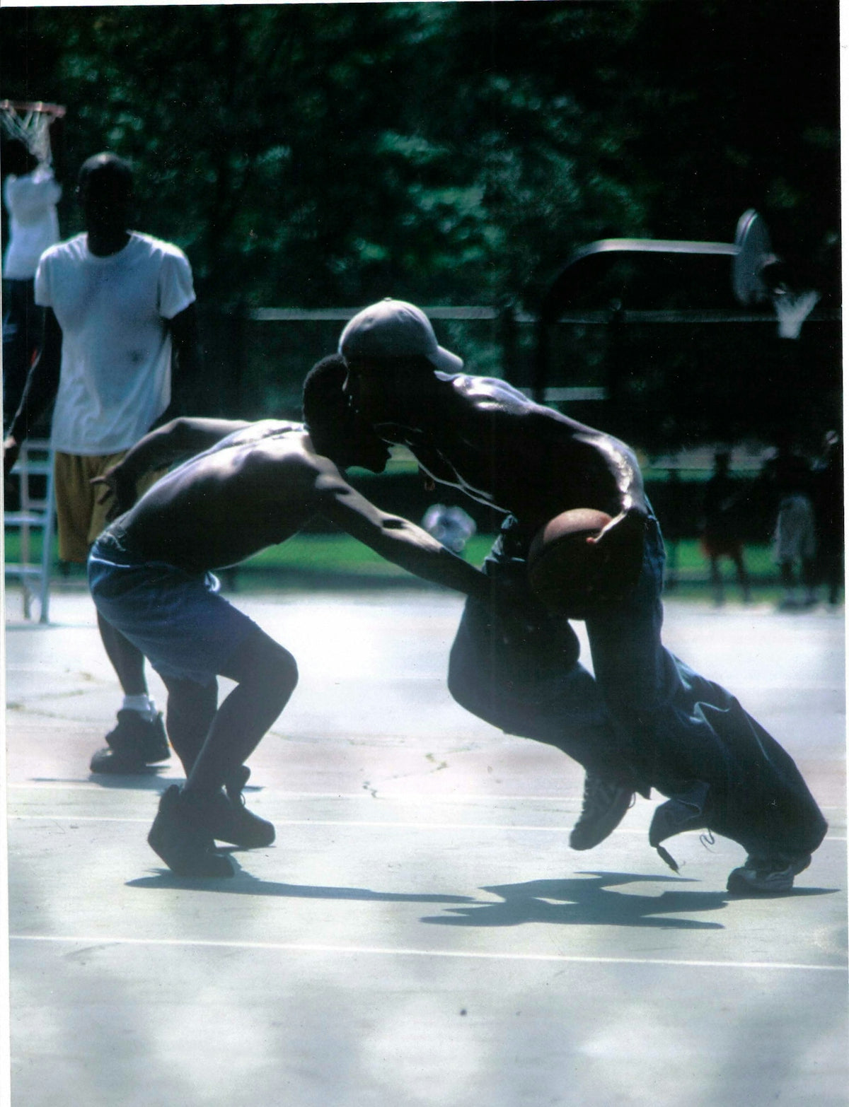 Two men play-fighting outdoors on a court.