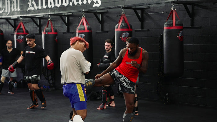 Men training kickboxing in a gym with punching bags