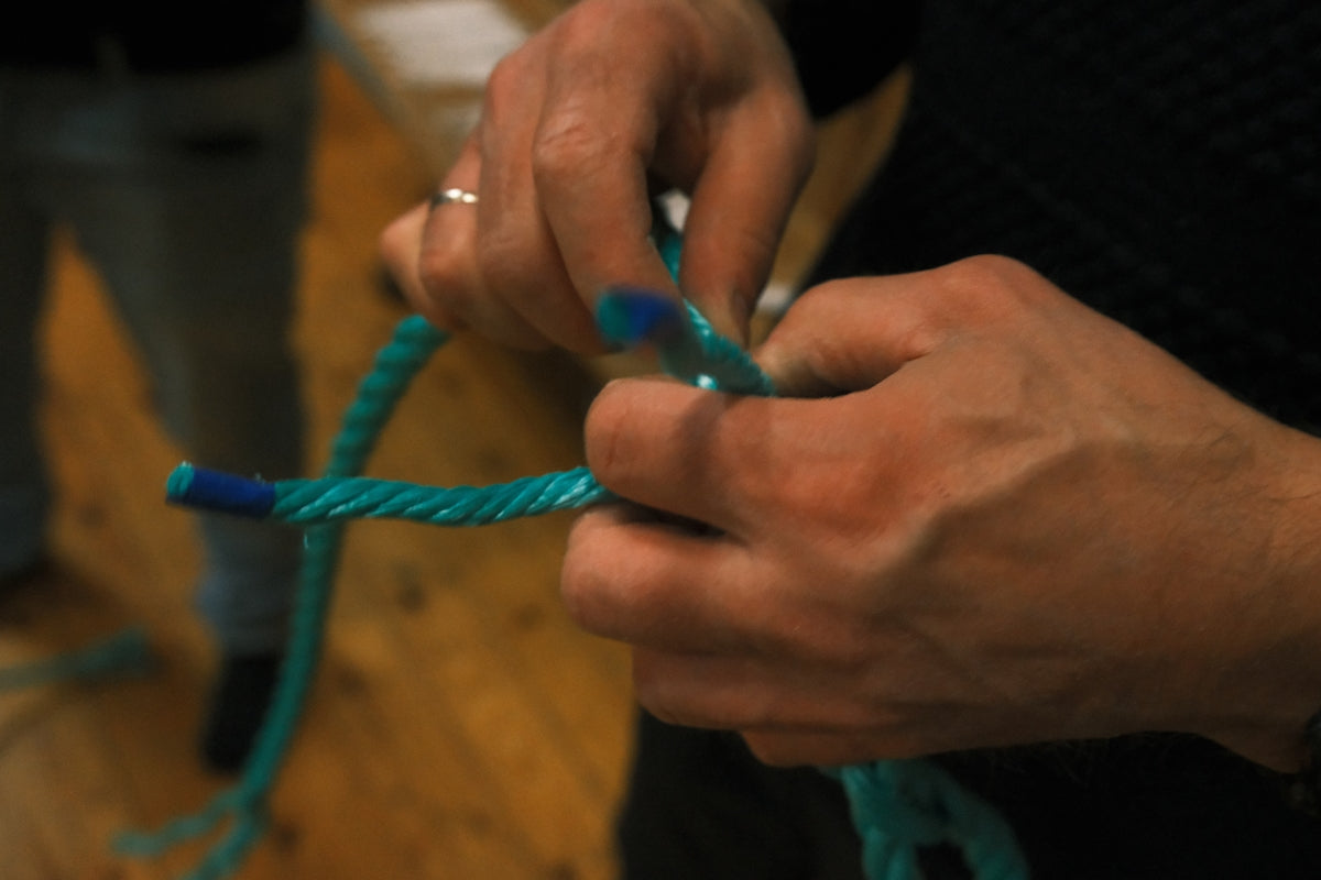 Hands tying a knot in thick rope