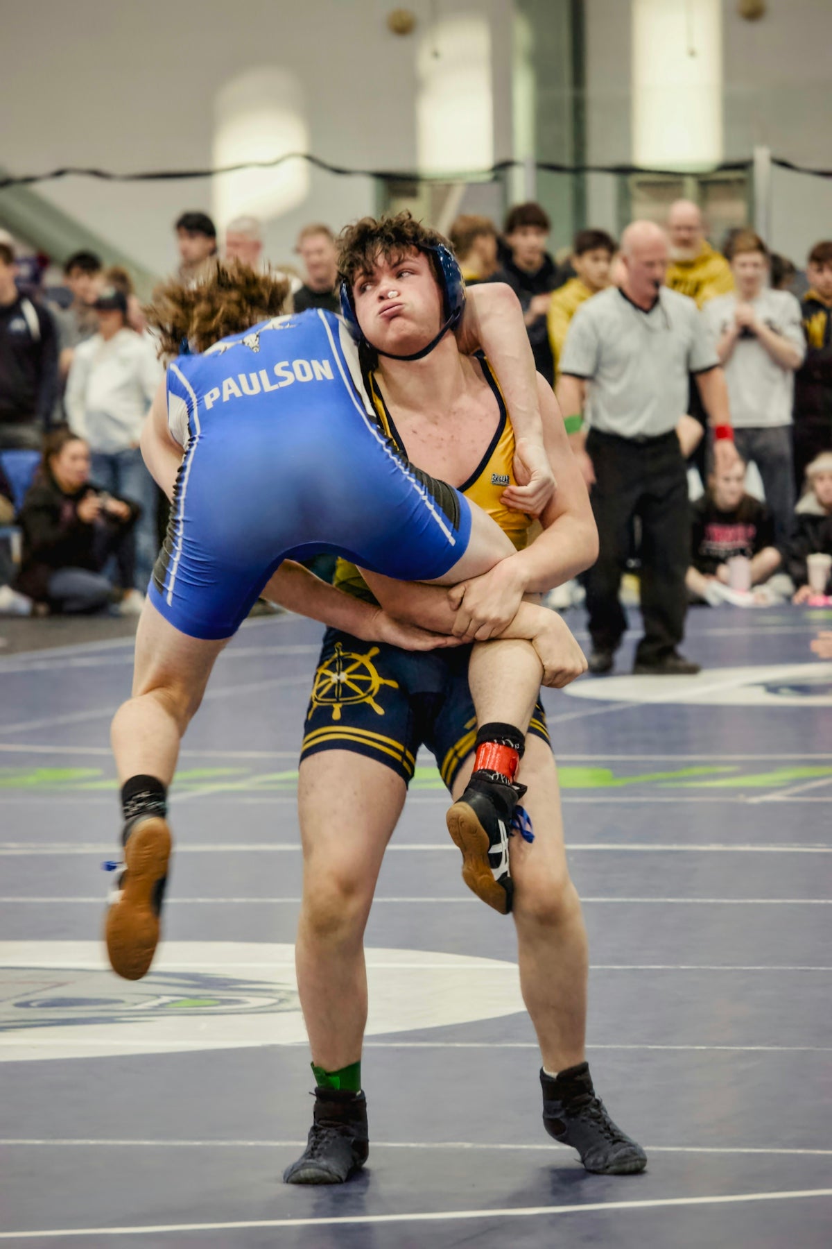 Two wrestlers grappling intensely during a match